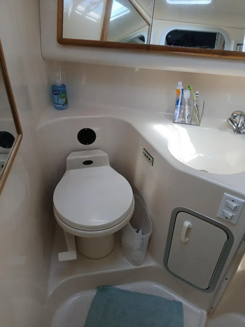 Slide: The Image of 1997 Sea Ray 370 Sundancer kitchen area with sink, fan, and storage cabinets. - 16