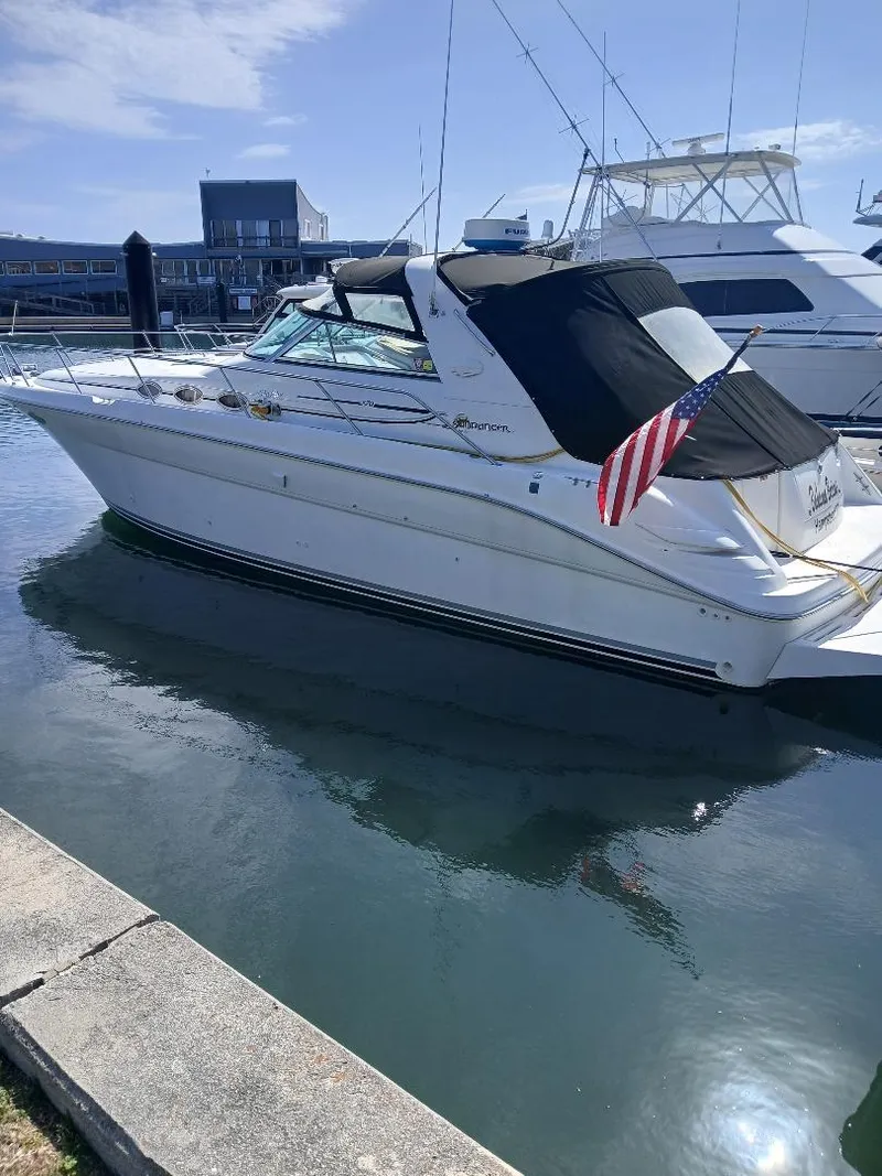 Slide: The Image of 1997 Sea Ray 370 Sundancer yacht docked, featuring sleek design and American flag. - 2