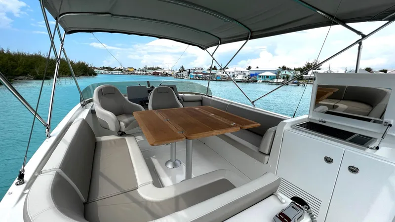 Slide: The Image of Beneteau Swift Trawler 44, 2020 model, featuring spacious deck with seating and table, docked in clear waters. - 13