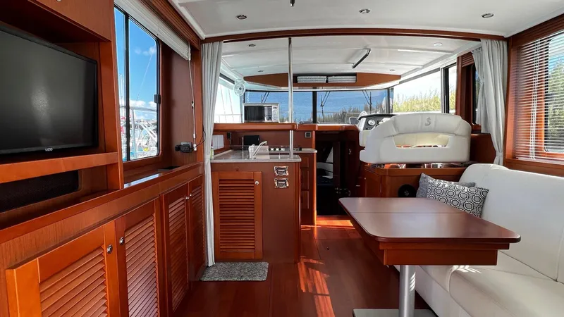 Slide: The Image of Interior of 2020 Beneteau Swift Trawler 44 with wood finish, seating, and kitchen area. - 41