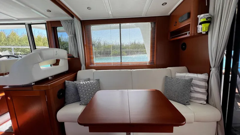 Slide: The Image of Interior of 2020 Beneteau Swift Trawler 44 with sofa, table, and window view. - 42