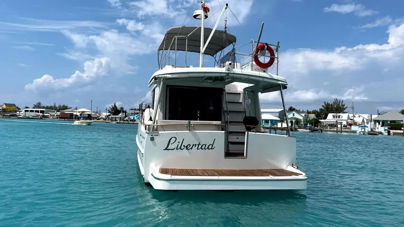 Slide: The Image of Beneteau Swift Trawler 44, 2020 model, named "Libertad" on turquoise water, clear sky. - 8