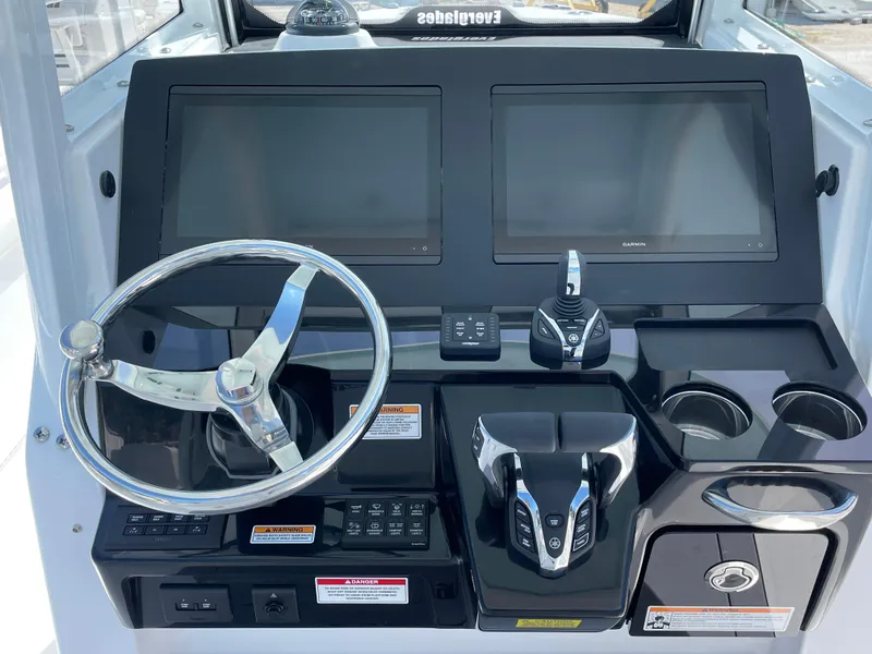 Slide: The Image of 2024 Everglades 285CC boat dashboard with dual screens and steering wheel. - 12