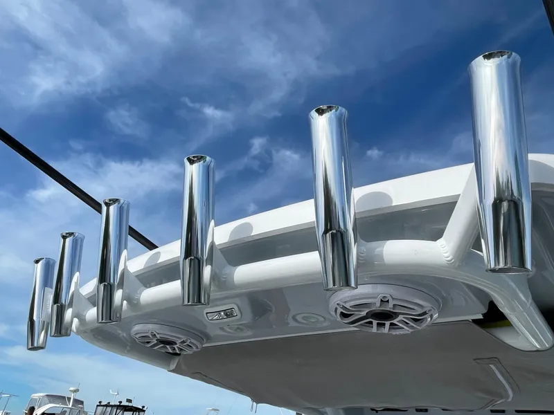 Slide: The Image of 2024 Everglades 285CC boat with chrome rod holders against a clear blue sky. - 16