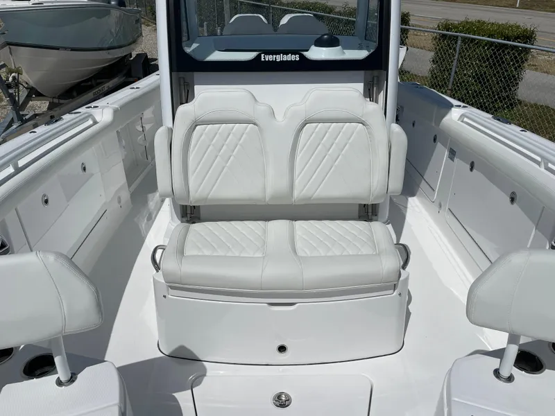 Slide: The Image of 2024 Everglades 285CC boat interior with white cushioned seating and sleek design. - 19