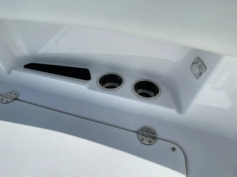 Slide: The Image of 2024 Everglades 285CC boat interior detail with cup holders and storage compartment. - 21