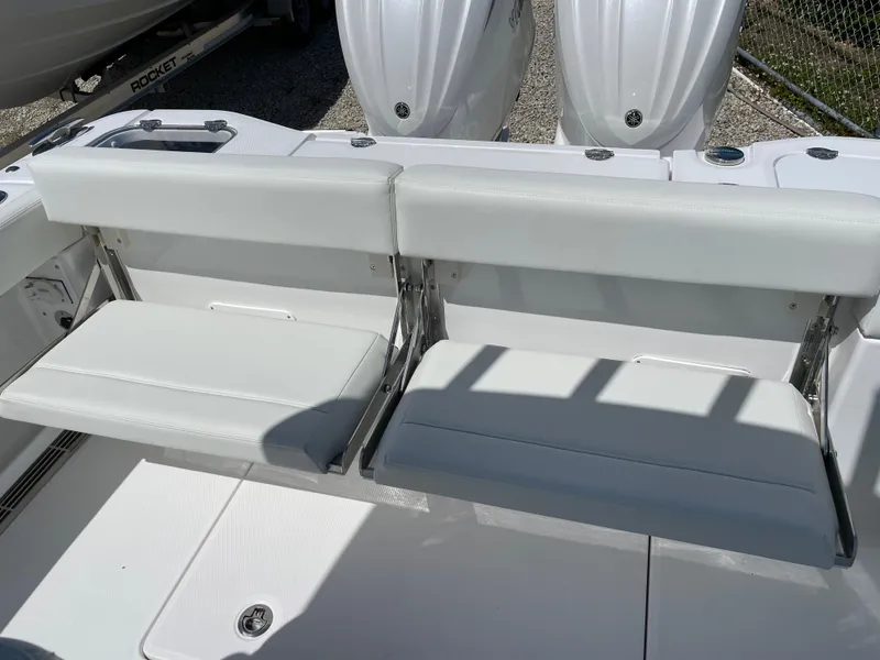 Slide: The Image of 2024 Everglades 285CC boat with white foldable seats and dual outboard engines. - 27