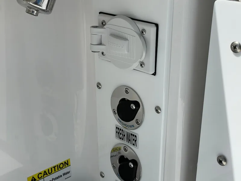 Slide: The Image of Freshwater access panel on 2024 Everglades 285CC boat, featuring caution label. - 28