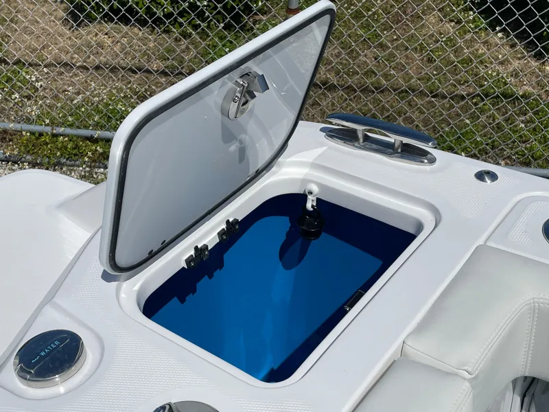 Slide: The Image of Open storage compartment on 2024 Everglades 285CC boat, featuring sleek design and blue interior. - 8