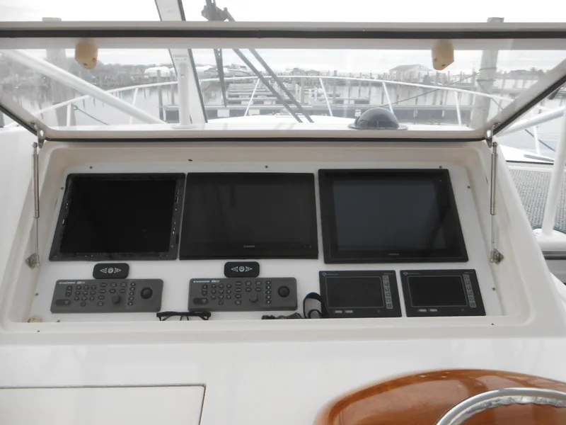 Slide: The Image of Control panel of 2007 Viking Boats 52 Open with multiple screens and navigation equipment. - 13
