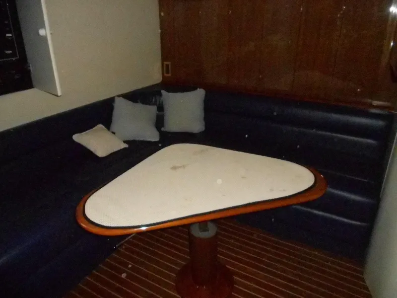 Slide: The Image of Interior of 2007 Viking Boats 52 Open with triangular table and cushioned seating. - 20