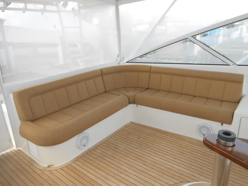 Slide: The Image of Luxurious seating area on 2007 Viking Boats 52 Open with tan cushions and teak flooring. - 23