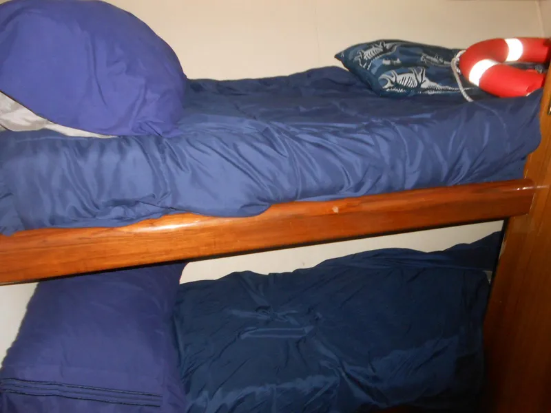 Slide: The Image of Bunk beds with blue bedding in a 2007 Viking Boats 52 Open cabin. - 25