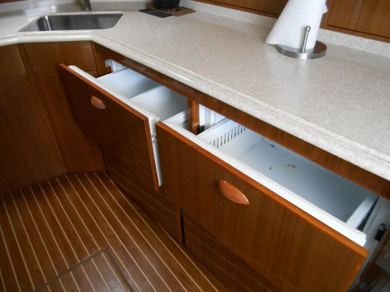 Slide: The Image of 2007 Viking Boats 52 Open kitchen with open wooden cabinets and countertop. - 29