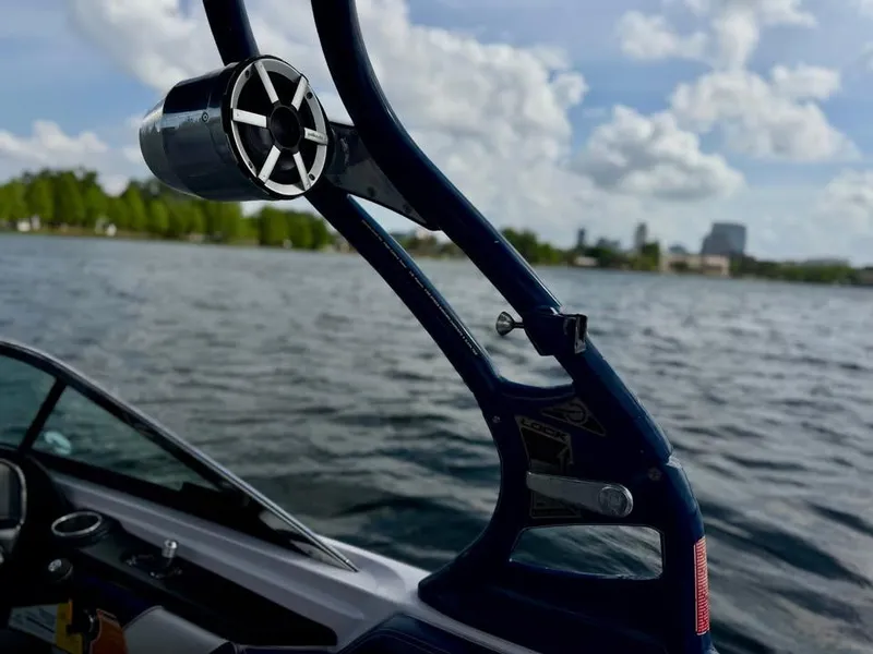 Slide: The Image of 2011 Nautique 200V boat on water, featuring a sleek speaker and tower against a cloudy sky. - 12