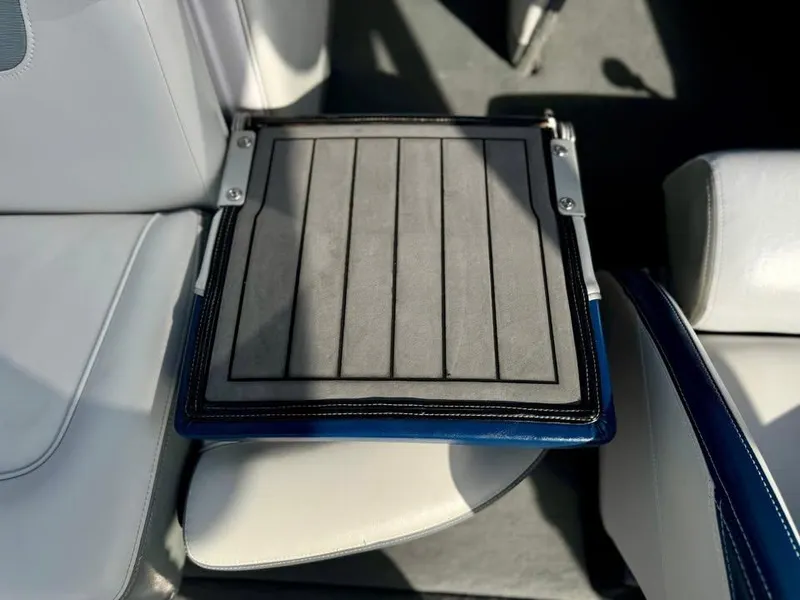 Slide: The Image of 2011 Nautique 200V boat seat with a foldable step, featuring gray and blue accents. - 15
