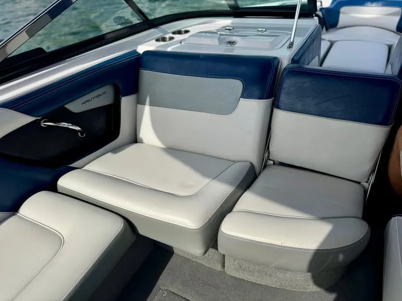 Slide: The Image of 2011 Nautique 200V boat interior with blue and gray seating, cup holders, and sleek design. - 16
