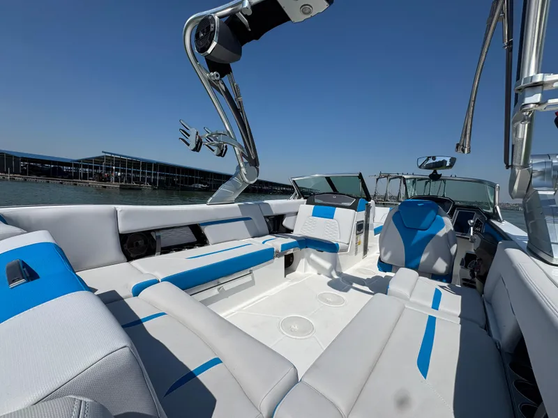 Slide: The Image of 2019 MasterCraft X24 boat interior with blue and white seating, sleek design, and open water view. - 22
