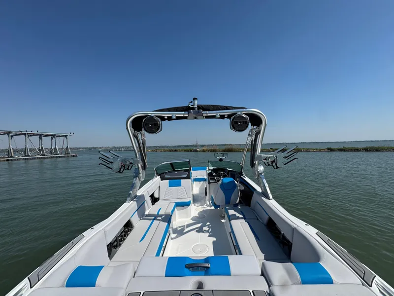 Slide: The Image of 2019 MasterCraft X24 boat interior with blue and white seating on a sunny day. - 26