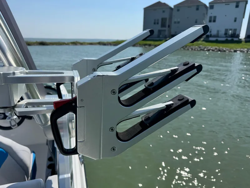 Slide: The Image of 2019 MasterCraft X24 wakeboard rack by the water with houses in the background. - 29