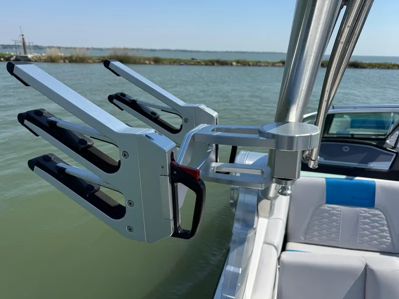 Slide: The Image of 2019 MasterCraft X24 boat with wakeboard rack on a sunny day by the water. - 30
