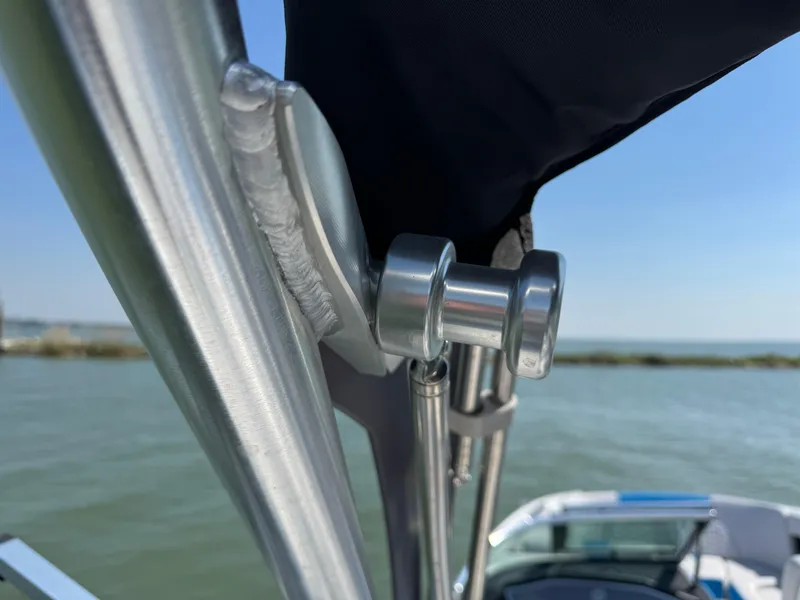 Slide: The Image of Close-up of 2019 MasterCraft X24 boat canopy hardware by the water. - 31