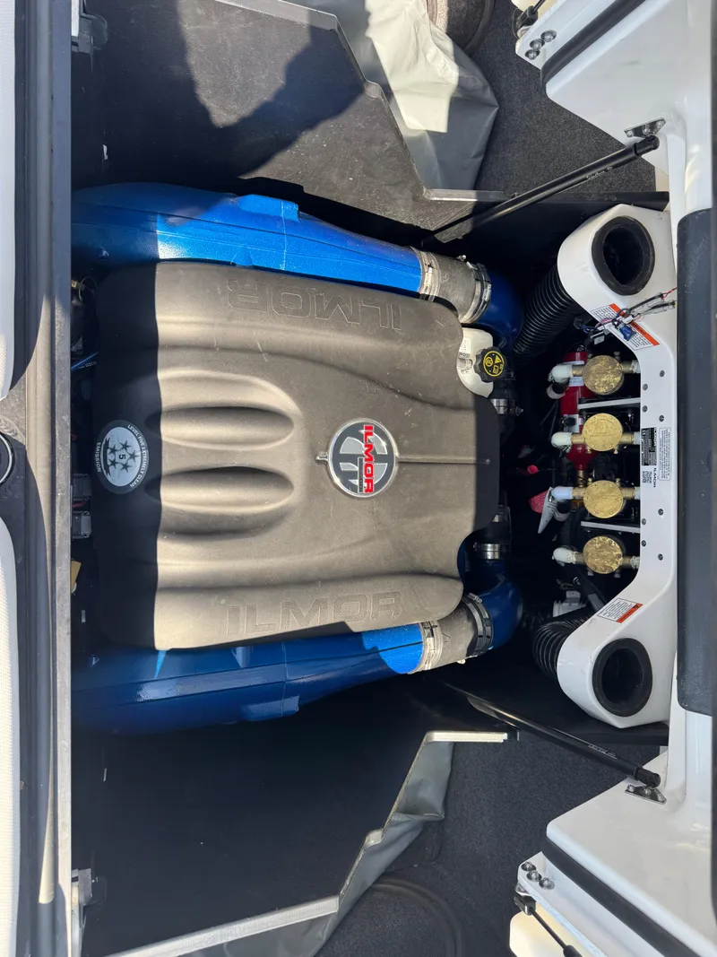 Slide: The Image of 2019 MasterCraft X24 engine compartment with Ilmor engine, featuring blue hoses and detailed components. - 36