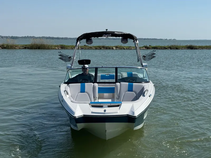 Slide: The Image of 2019 MasterCraft X24 boat on calm water, featuring sleek design and spacious seating. - 6