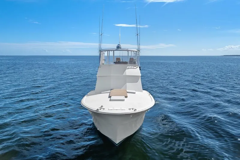 Slide: The Image of 1978 Hatteras 45 Convertible yacht on open sea under clear blue sky. - 13
