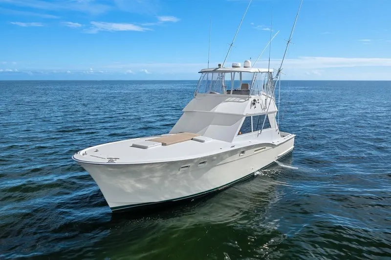 Slide: The Image of 1978 Hatteras 45 Convertible yacht cruising on open sea under clear blue sky. - 14