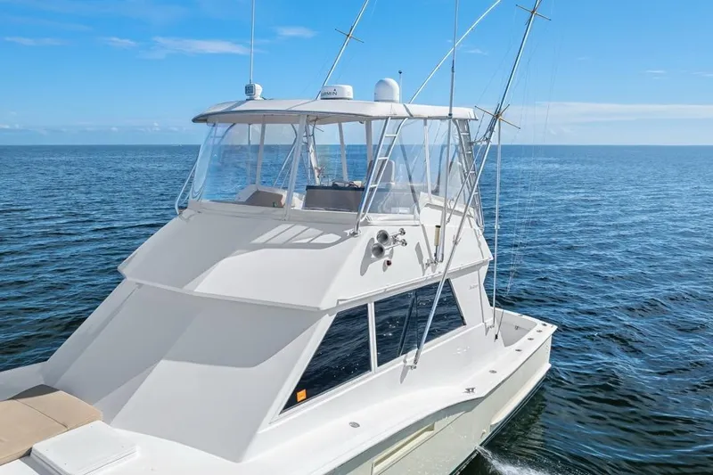 Slide: The Image of 1978 Hatteras 45 Convertible yacht cruising on open sea under clear blue sky. - 15