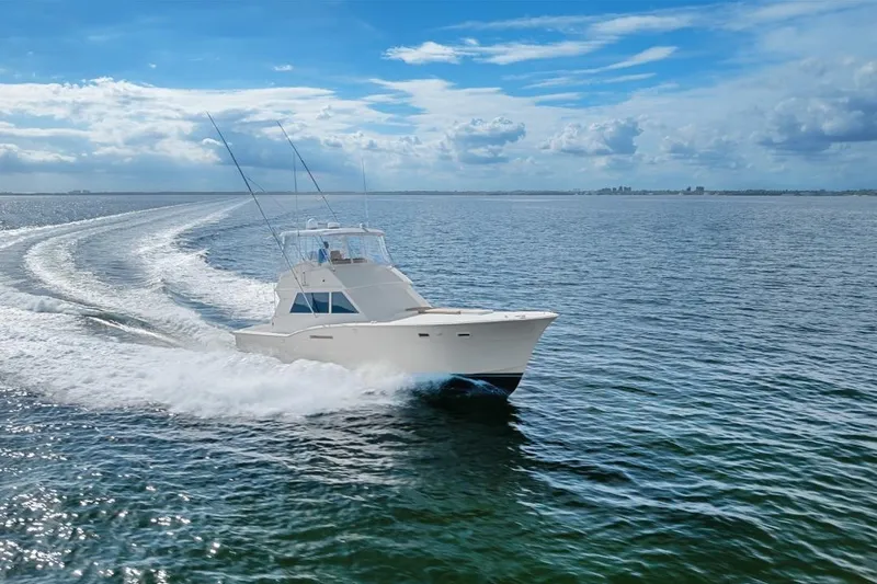 Slide: The Image of 1978 Hatteras 45 Convertible yacht cruising on open water under blue skies. - 22