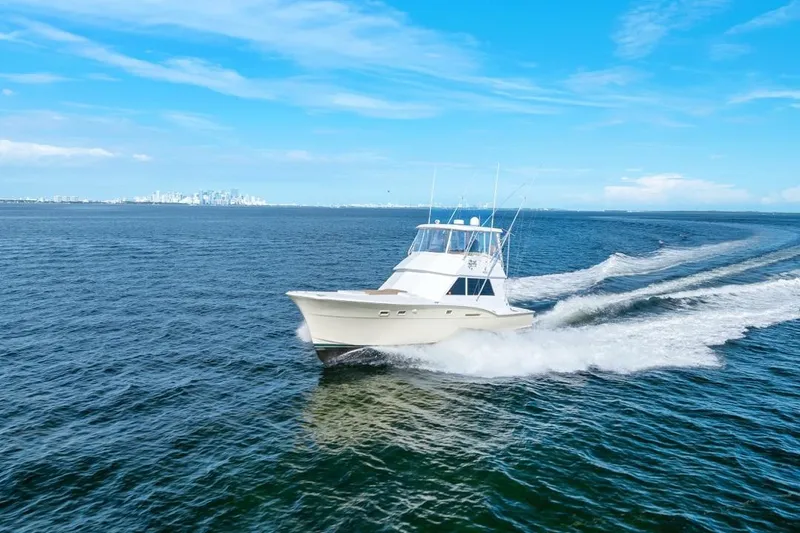 Slide: The Image of 1978 Hatteras 45 Convertible yacht cruising on open blue sea under clear sky. - 23