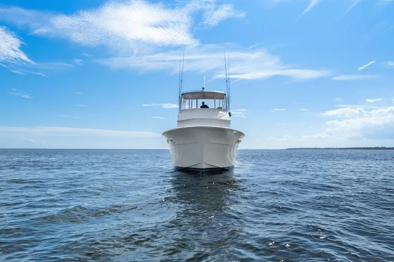 Slide: The Image of 1978 Hatteras 45 Convertible yacht on open water under a clear blue sky. - 3