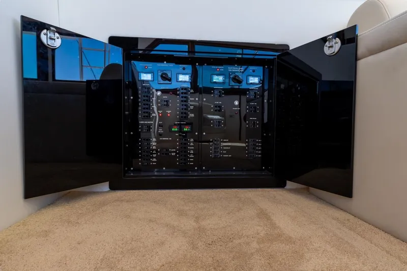 Slide: The Image of Electrical panel inside 1978 Hatteras 45 Convertible yacht, featuring open black cabinet doors. - 34