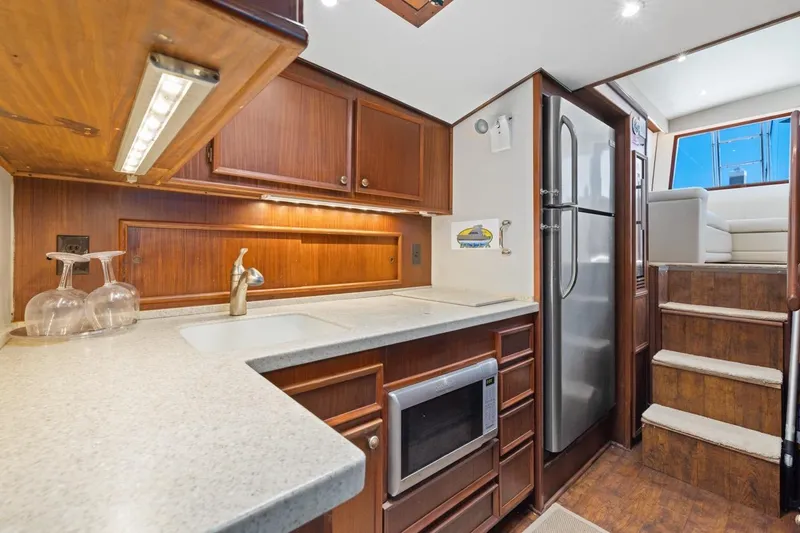 Slide: The Image of 1978 Hatteras 45 Convertible yacht kitchen with wood cabinetry and modern appliances. - 36