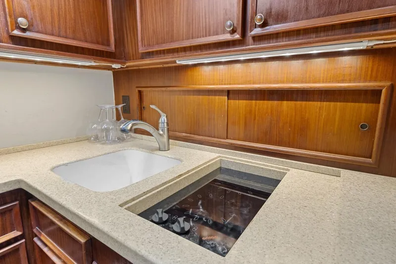 Slide: The Image of 1978 Hatteras 45 Convertible yacht kitchen with sink and stove, wooden cabinetry. - 37