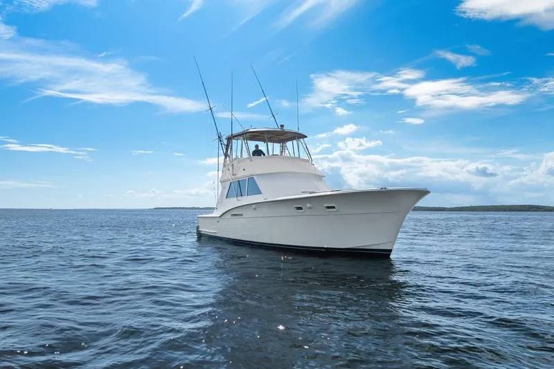 Slide: The Image of 1978 Hatteras 45 Convertible yacht on open water under a clear blue sky. - 4