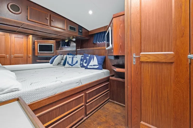 Slide: The Image of 1978 Hatteras 45 Convertible yacht cabin with wooden interior and nautical-themed pillows. - 40