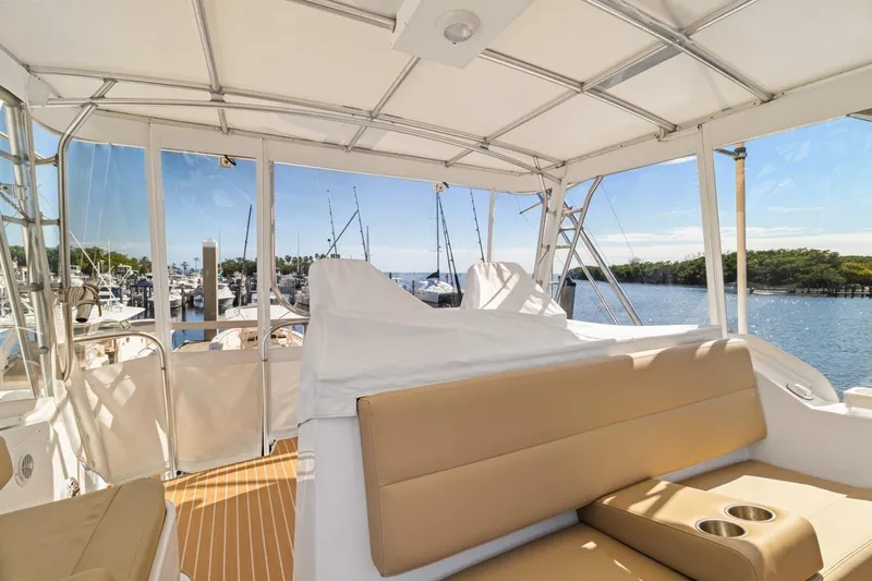 Slide: The Image of 1978 Hatteras 45 Convertible yacht interior with beige seating, overlooking marina and water. - 43