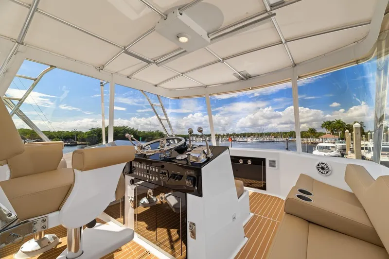 Slide: The Image of Interior view of 1978 Hatteras 45 Convertible yacht helm with scenic marina backdrop. - 48
