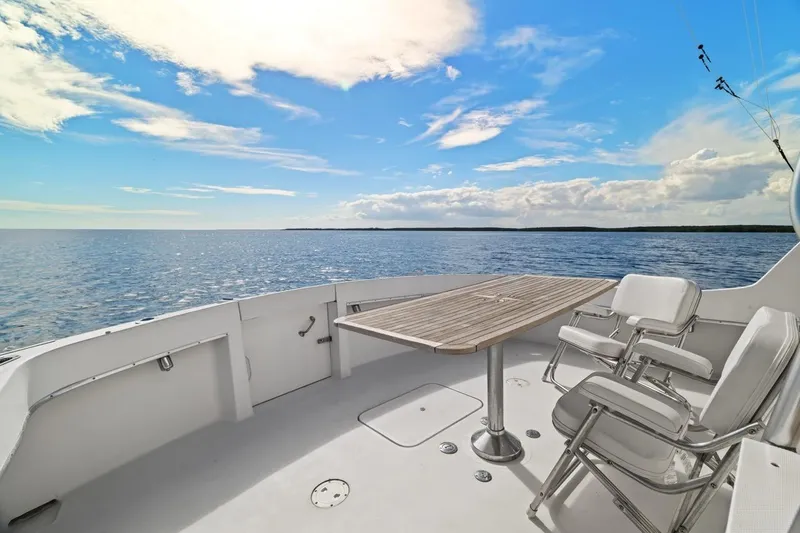 Slide: The Image of 1978 Hatteras 45 Convertible yacht deck with chairs, table, and ocean view. - 52