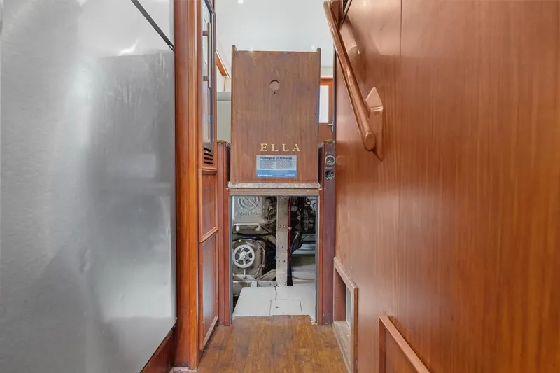 Slide: The Image of 1978 Hatteras 45 Convertible yacht interior with wooden paneling and engine room access. - 58