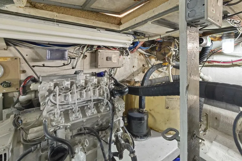 Slide: The Image of Engine room of 1978 Hatteras 45 Convertible boat, showcasing mechanical components and wiring. - 64