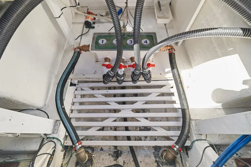 Slide: The Image of Engine room of 1978 Hatteras 45 Convertible boat with visible hoses and valves. - 68