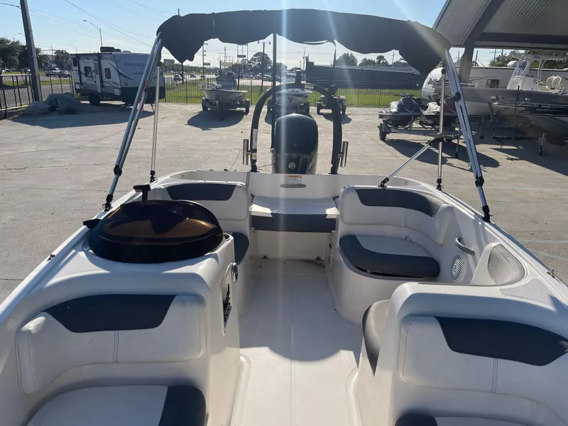 Slide: The Image of 2017 Bayliner Element E16 boat with seating and canopy in a marina setting. - 7