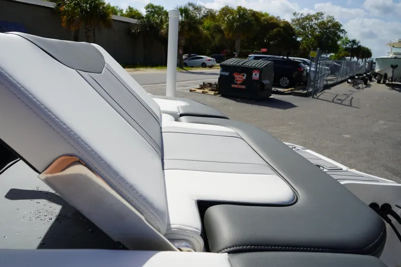 Slide: The Image of 2023 Chaparral 21 SSi OB boat seat, gray and white upholstery, outdoor setting. - 12