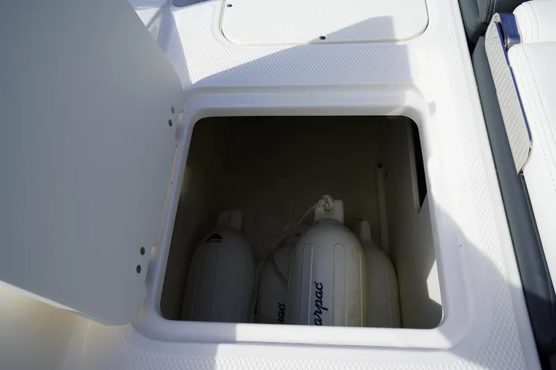 Slide: The Image of Storage compartment on 2023 Chaparral 21 SSi OB boat, featuring fenders inside. - 14