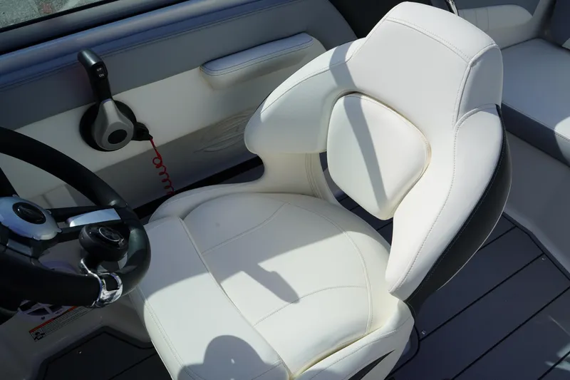 Slide: The Image of 2023 Chaparral 21 SSi OB boat interior with white captain's chair and steering wheel. - 22