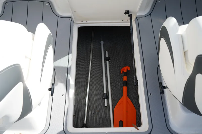 Slide: The Image of 2023 Chaparral 21 SSi OB boat storage compartment with paddle and equipment. - 24